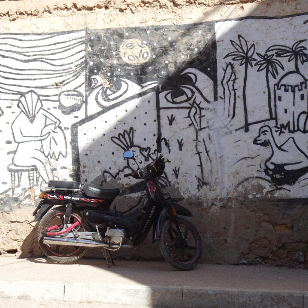 Streets of Taghazout, Morocco, with graffiti and scooter